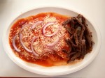 Enchiladas with beef and salsa roja - spicy red salsa, topped with cheese and onion slices. Enchiladas with beef and salsa roja - spicy red salsa, topped with cheese and onion slices.