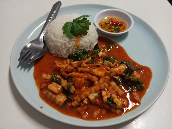 Red curry paste with fried young coconut and basil leaves served with rice Red curry paste with fried young coconut and basil leaves served with rice