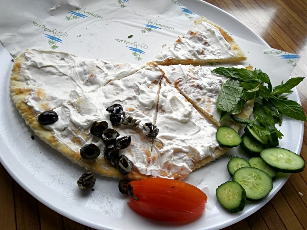 Manouche with labneh garnished with peppermint, tomatoes, black olives and cucumber slices. Manouche with labneh garnished with peppermint, tomatoes, black olives and cucumber slices.