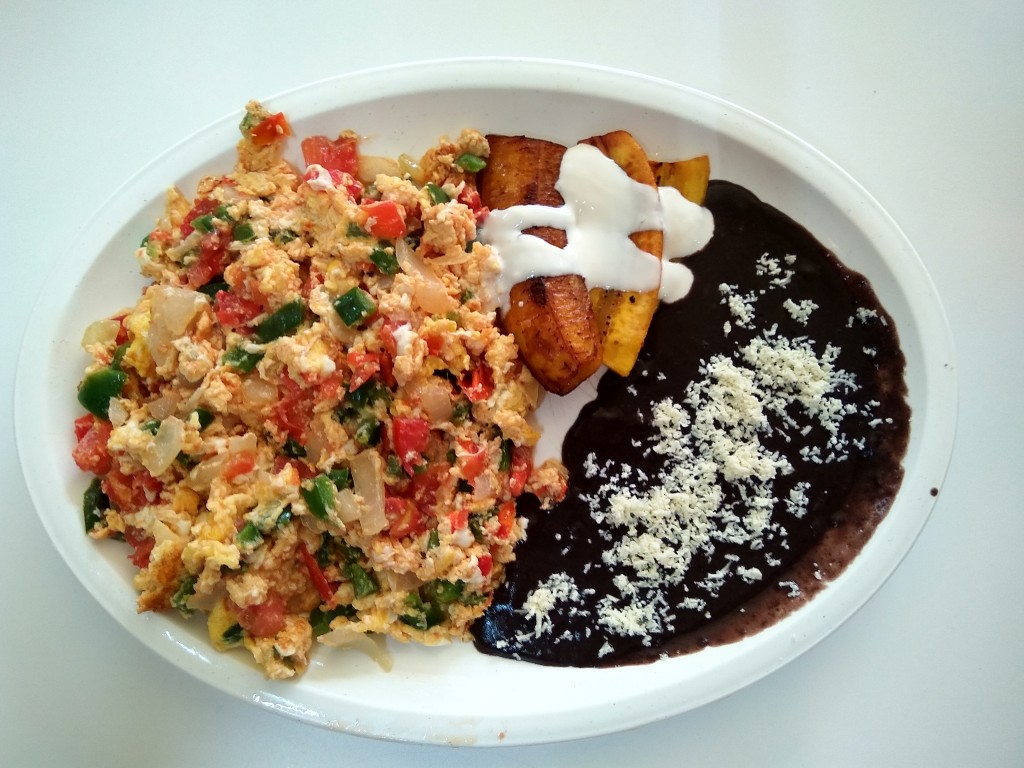 Huevos revueltos a la Mexicana con platanos fritos y frijoles. Mexican style scrambled eggs with onion, tomatoes and habanero, served with fried beans and deep fried bananas topped with cream. Huevos revueltos a la Mexicana con platanos fritos y frijoles. Mexican style scrambled eggs with onion, tomatoes and habanero, served with fried beans and deep fried bananas topped with cream.