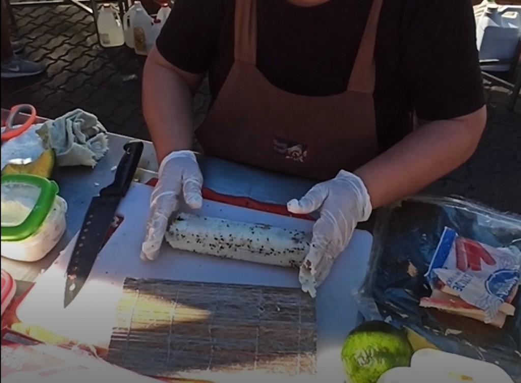 10. Place your roll on one edge of the sesame stripe and start rolling it, so that sesame seeds decorate the sushi roll 10. Place your roll on one edge of the sesame stripe and start rolling it, so that sesame seeds decorate the sushi roll